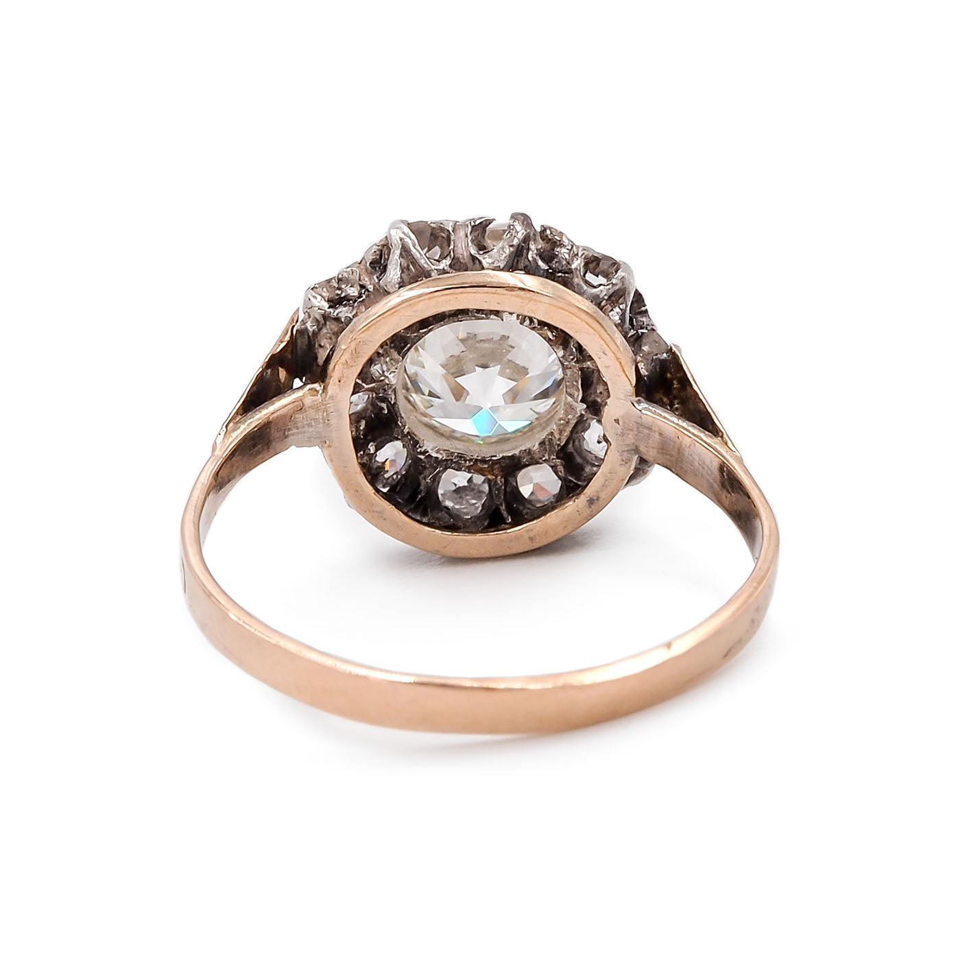 Antique Victorian ring with central gemstone and smaller stones on a white background