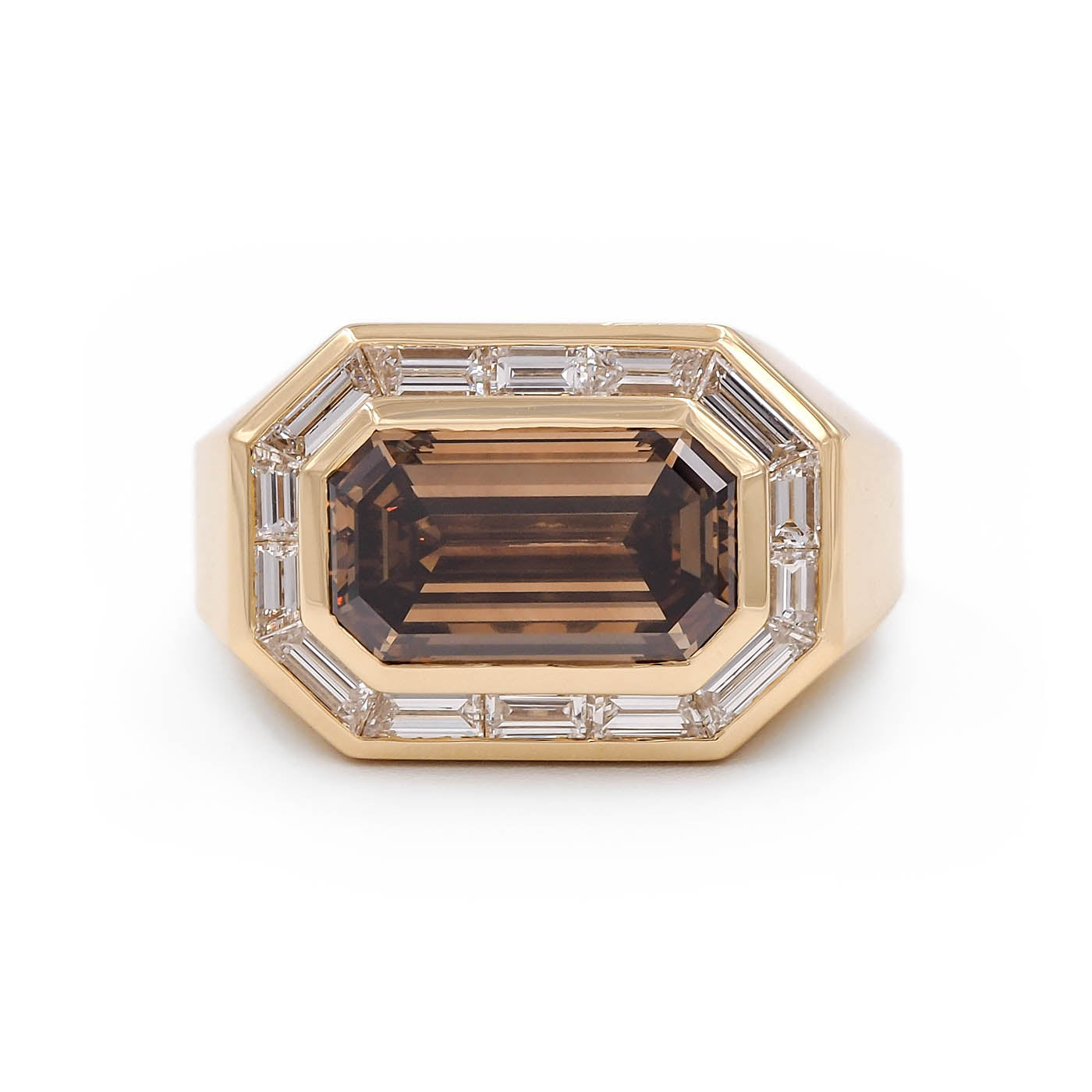 Gold ring with a large brown gemstone and smaller clear stones on a white background