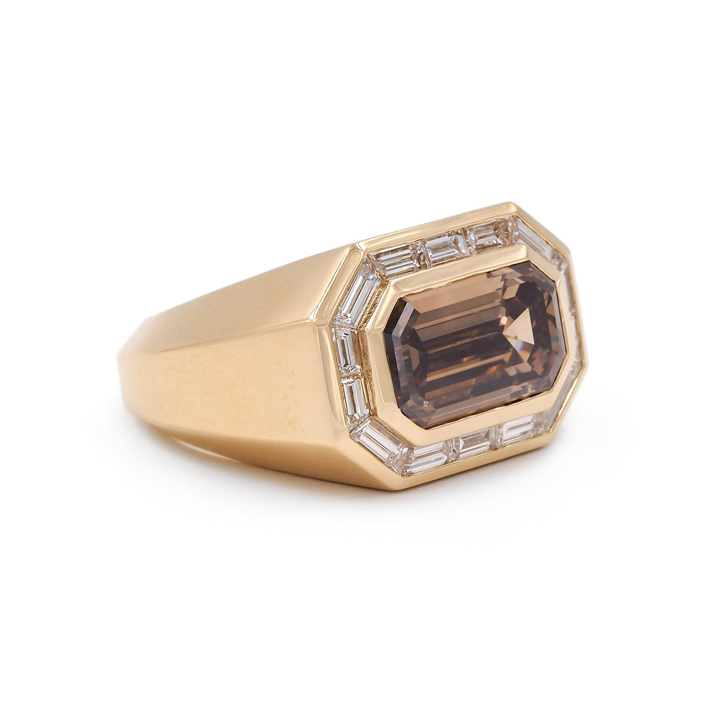 Gold ring with a large brown gemstone and smaller clear stones on a white background