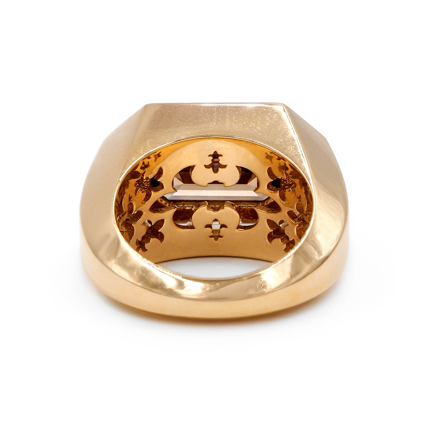 Gold ring with intricate design on a white background