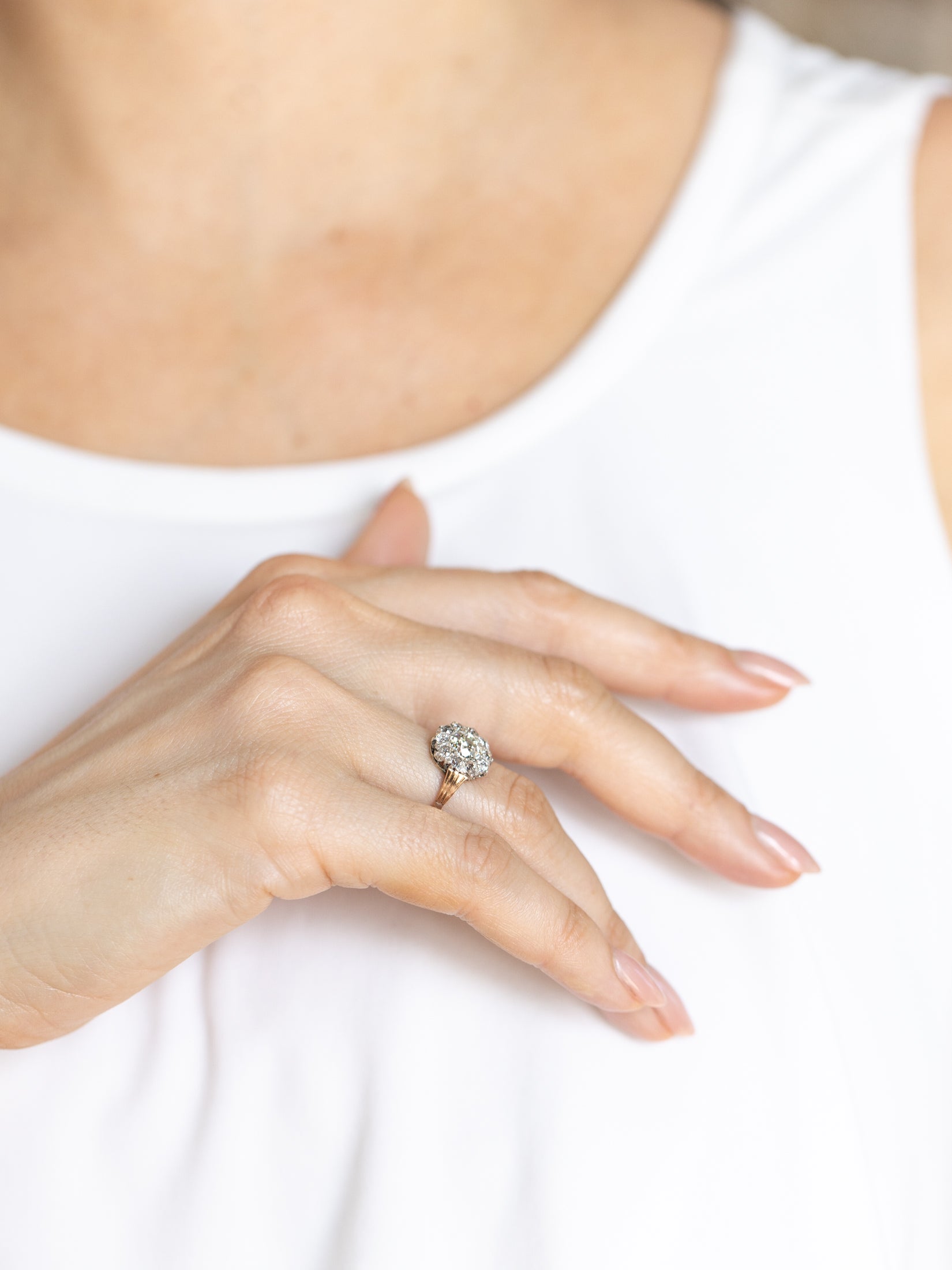Close-up of a hand wearing a diamond ring on a white background