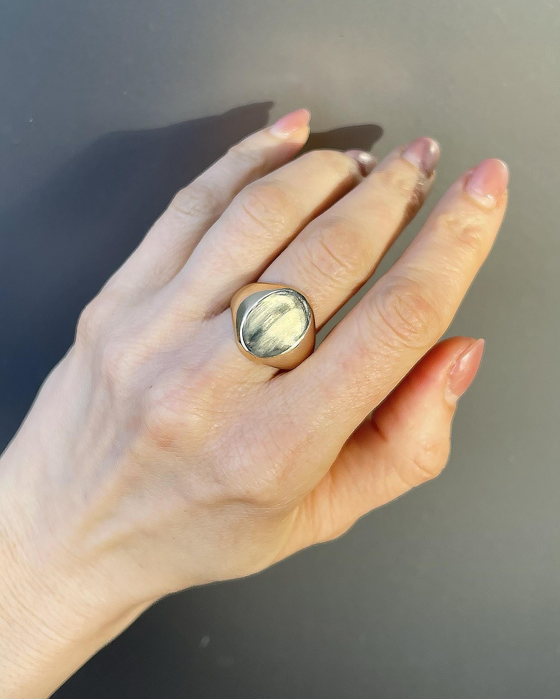 Authentic vintage oval signet ring in polished yellow gold, classic domed face on woman's hand